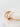 Gold hoop earring on a white cushion
