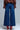 Back view of indigo wide leg jeans with high-rise fit and full-length silhouette, styled with red heels
