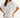 Woman wearing a white blouse with embroidery on a plain background