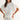 Woman wearing a white blouse with embroidery on a plain background