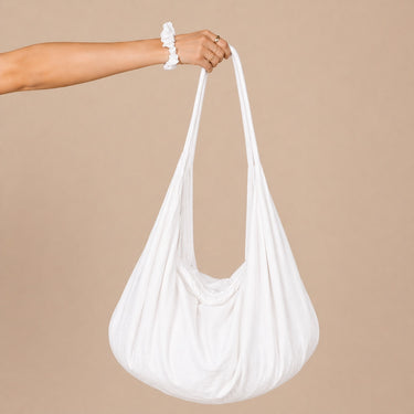 Jaspe Beach Bag in clean white cotton with oversized slouchy shape and long shoulder strap, featuring a minimalist, relaxed design.