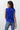 Kian Top worn by model, back view, showing sleeveless cut and relaxed draped fit in blue fabric.
