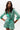 A female model wearing a green metallic foil print linen shirt with a V-neckline and a belt.