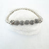 A stretch bracelet with silver-colored beads, displayed on a white surface.