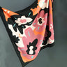 Lasso Scarf in vibrant coral, black, and blush tones with abstract floral print, silky satin texture, square shape — statement accessory from Matte.
