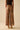 Leopard print pants worn by a person on a beige background