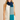 Woman wearing Linda Scarf in color-block blue and teal knit, styled over a white sleeveless top.
