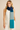 Woman wearing Linda Scarf in color-block blue and teal knit, styled over a white sleeveless top.