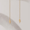 Gold lightning bolt Lirien earrings on a light background