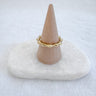 Textured bamboo-inspired ring in gold tones displayed on marble stone – Lisa Ring by Matte.