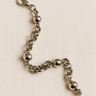 Loopa Bracelet — sculptural silver bracelet with interlinked loops and polished spheres on linen background, modern minimalist jewelry by Matte.