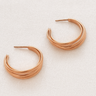 Luzia Hoop Earrings — layered gold plated hoops with modern curved design on beige linen background, polished and elegant jewelry by Matte.