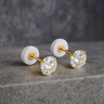 Gold 4 mm stud earrings with round cubic zirconia on a neutral stone background – Maelle Stud Earrings by Matte