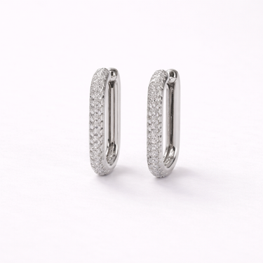 Malath Huggie Earrings in silver featuring slim hoop design with pavé-set cubic zirconia stones, displayed on a soft neutral background, minimalist everyday huggie earrings
