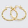 Polished gold hoop earrings with a sleek rounded silhouette and secure latch closure on a light neutral background - Matte Jewelry
