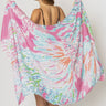 Woman wearing Maranola Sarong in pink tropical print, draped as a beach wrap over swimwear.