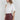 Maratea Blouse worn by model, angled view, showing fluid drape and modern sleeveless silhouette.