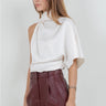 Maratea Blouse worn by model, angled view, showing fluid drape and modern sleeveless silhouette.