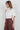 Maratea Blouse worn by model, angled view, showing fluid drape and modern sleeveless silhouette.
