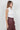 Maratea Blouse worn by model, side view, highlighting asymmetric design and soft scarf wrapped around.