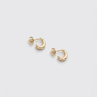 Margo Hoops gold mini hoop earrings with a polished rounded silhouette, open crescent shape, and post-back closure on a light gray background.