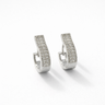 Maribella Huggie Earrings, silver crystal huggie earrings with hinged closure on background.