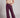 Front view of chocolate brown faux leather wide leg pants styled with beige top and sneakers, modern streetwear look