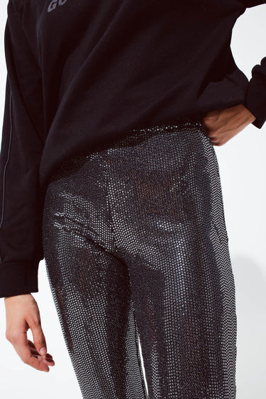 Close up of sparkling black sequin flare pants with fitted waist and shimmering texture, bold night-out piece