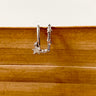 A gold-plated ear cuff with a star design displayed on a wooden surface.