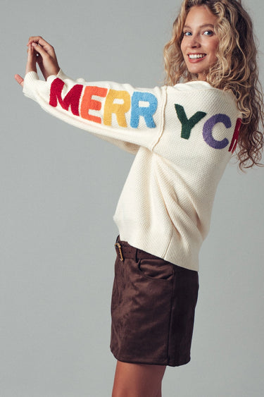 Side view of oversized Christmas knit sweater styled with brown corduroy pants.
