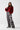 Full styled look of metallic floral wide leg trousers with red knit sweater and statement belt