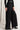 Side view of Midnight Lace Pants in black lace with satin waistband detail and flowing wide-leg cut.