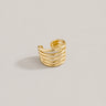 Mima Ear Cuff in polished gold featuring a wide layered open-band design with sleek stacked lines, styled as a bold modern statement ear cuff on a soft neutral background.