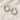 “Mindy Huggie Earrings in silver displayed on a soft beige fabric background.”