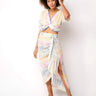 Woman wearing a pastel twist-front crop top in soft sunset tones — lightweight resort style by Matte.