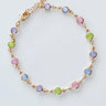 Delicate gold bracelet with pastel stones laid on white surface — Mirlo Bracelet by Matte.