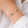 Neroni Bracelet delicate silver chain bracelet with emerald green stones on wrist.