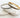 Gold and silver slim bangle bracelets with crystal accents resting on white stone background — Nina Bangle Bracelet by Matte.
