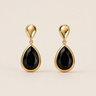 Nodar Stud Earrings gold earrings with black teardrop stones on neutral background, showing polished gold setting and bold contrast design