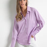 Relaxed pose of model wearing Noema Lilac Shirt in lilac cotton for casual chic style.