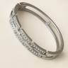Odie Bangle Bracelet — polished gunmetal silver bangle with crystal accents on beige linen background, sleek and reflective by Matte.