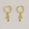 Opira Huggie Earrings — gold plated huggies with serpent charm, white crystals and green stone eye on linen background, elegant and symbolic jewelry by Matte.