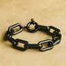 Orla Bracelet — black mirror chain bracelet with high-shine links and toggle clasp on beige background, statement jewelry by Matte.
