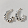 Oudenaarde Hoop Earrings featuring polished silver-plated hoop earrings with graduated bubble bead detailing, a rounded chunky silhouette, mirror finish, secure post-back closure, lightweight design, and bold statement style.