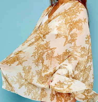 Woman wearing Pinto Sarong in yellow sea-inspired print, styled over swimsuit.