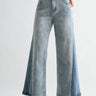 Person wearing light blue wide-leg jeans on a white background