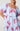 Model wearing light blue mini dress with puff sleeves and pink animal print