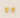Gold heart-shaped Romy earrings on a beige fabric background