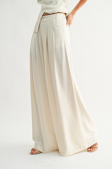 Rumi Pant cream wide-leg trousers side profile view showing flowing drape and relaxed elegant leg line.