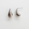Sage Stud Earrings — sculpted silver-plated spiral stud earrings on white linen background, minimalist polished jewelry by Matte.